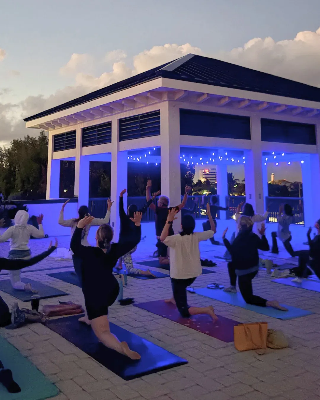People practicing yoga on a rooftop under a full moon