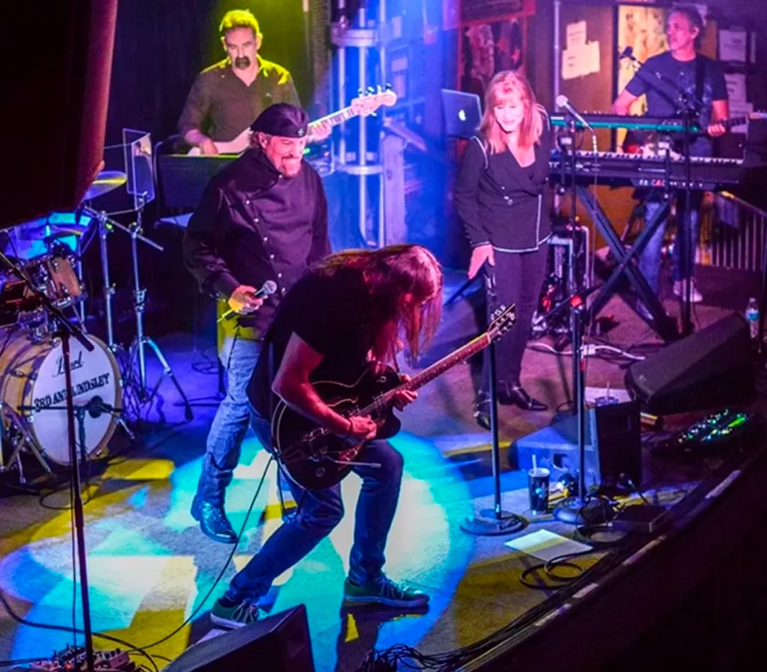 A tribute band performing on stage, recreating the music of Toto.