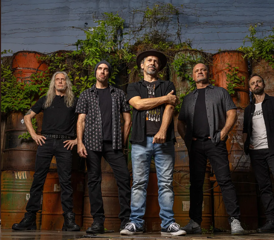 A band performing on stage with instruments, recreating the music of Pearl Jam.