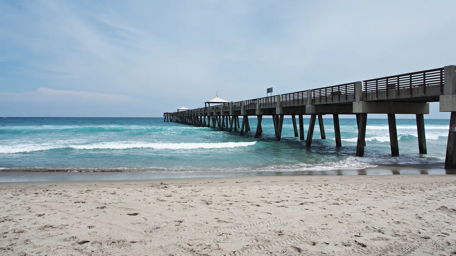 The Juno Beach fishing pier extending out over the ocean.